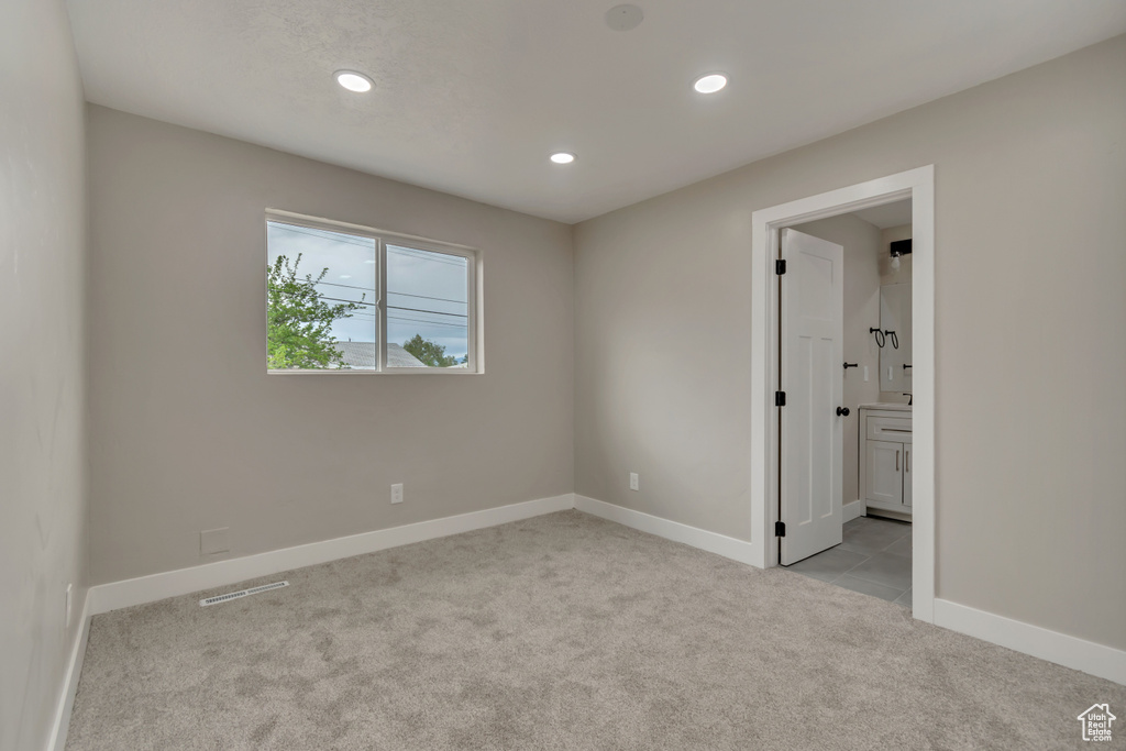 Empty room featuring light colored carpet, recessed lighting, and baseboards