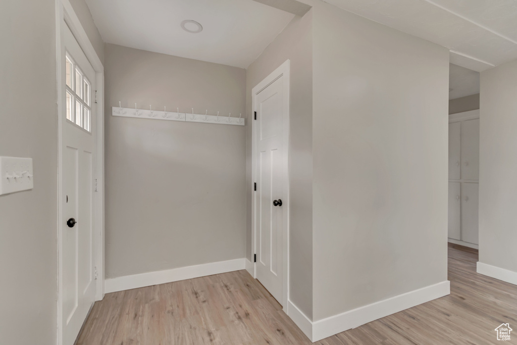 Corridor with light wood-style flooring and baseboards
