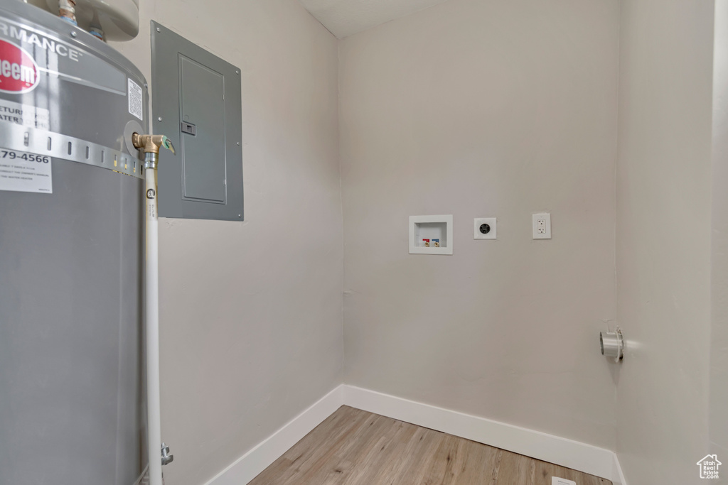 Washroom featuring hookup for an electric dryer, electric panel, baseboards, hookup for a washing machine, and light wood-type flooring