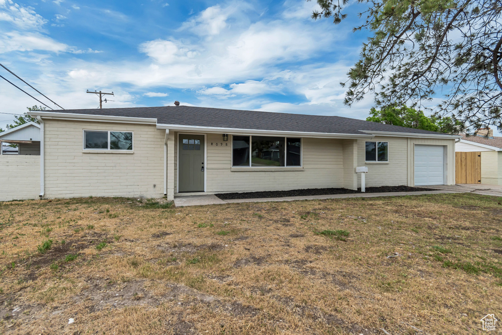Ranch-style home with a garage, brick siding, a porch, a front lawn, and roof with shingles