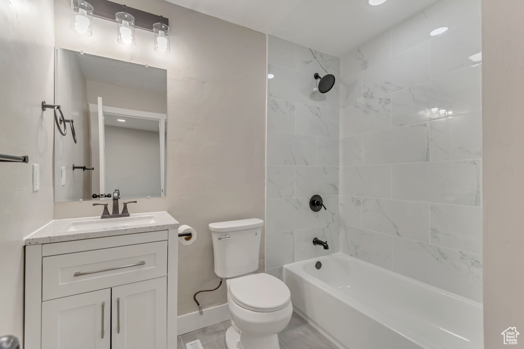 Full bath featuring toilet, vanity, baseboards, and shower / washtub combination