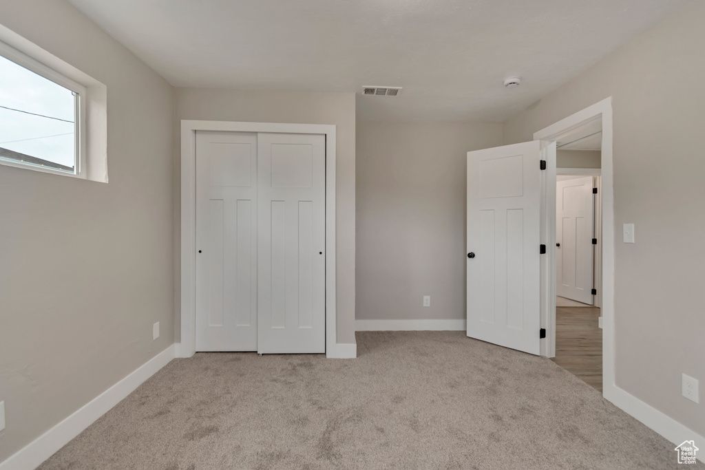 Unfurnished bedroom with carpet, baseboards, and a closet