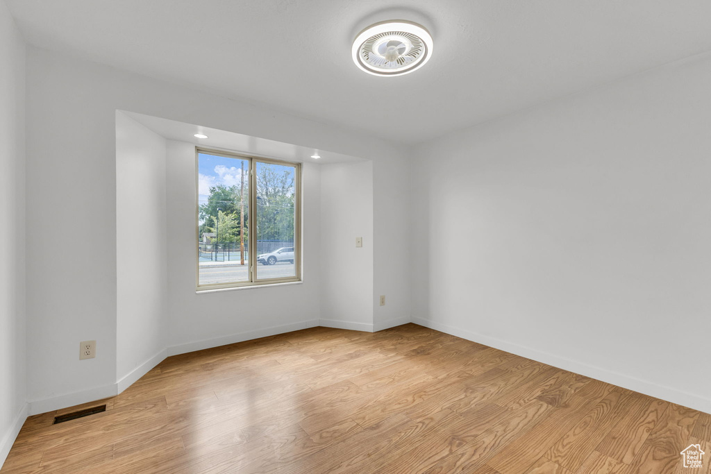 Spare room featuring light wood-type flooring and baseboards