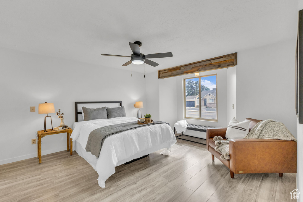 Bedroom featuring light wood finished floors, baseboards, and a ceiling fan