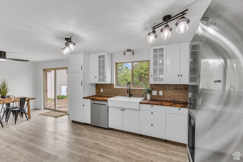Kitchen with stainless steel appliances, butcher block countertops, backsplash, and a sink