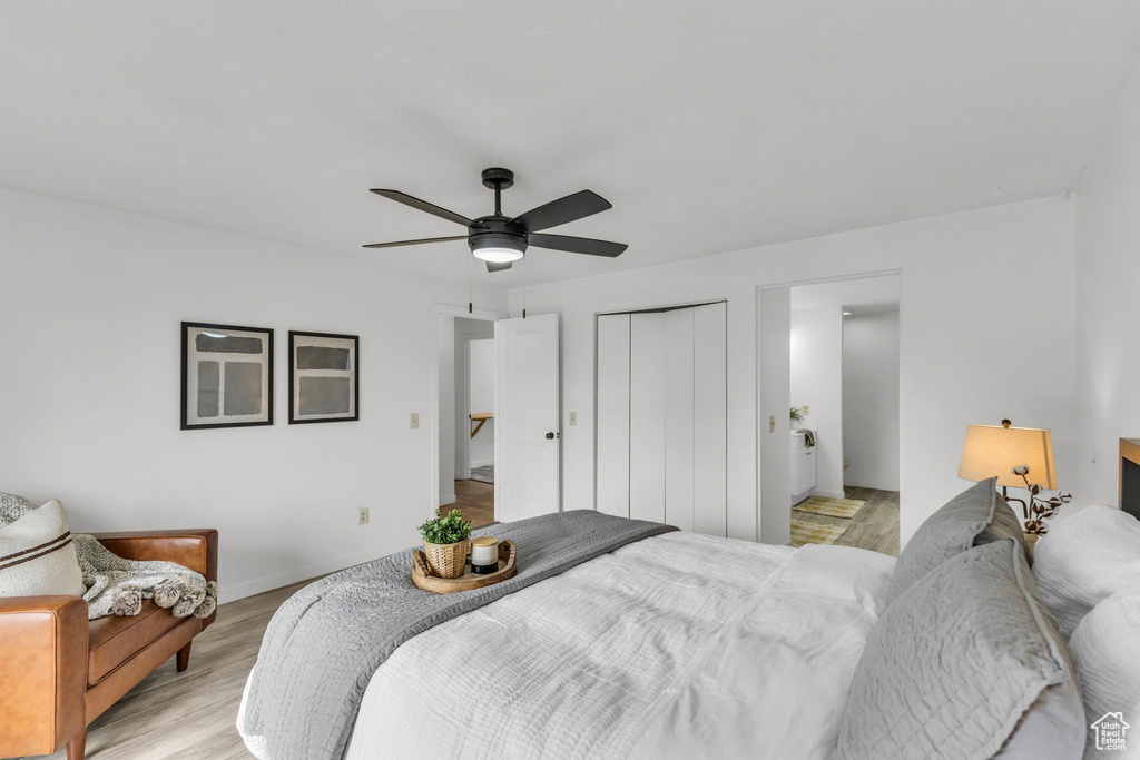 Bedroom with a closet, light wood-style flooring, a ceiling fan, and baseboards