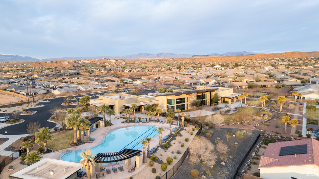 Aerial perspective of suburban area with a mountain backdrop and a pool area
