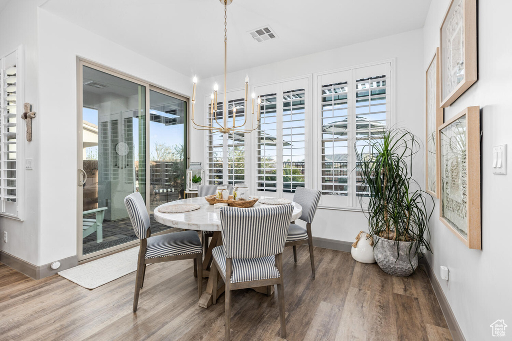 Dining space featuring a chandelier, wood finished floors, and baseboards
