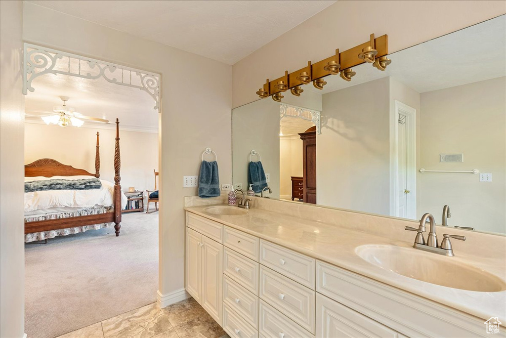 Ensuite bathroom featuring a sink, a ceiling fan, ensuite bath, and double vanity