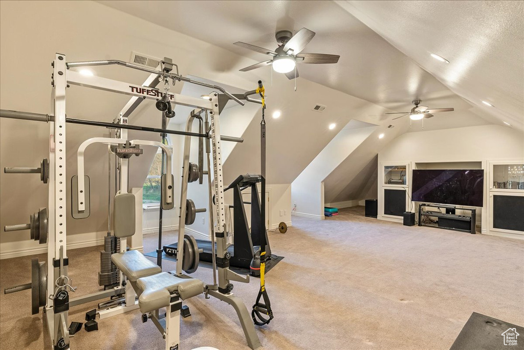 Exercise area featuring visible vents, baseboards, ceiling fan, and lofted ceiling