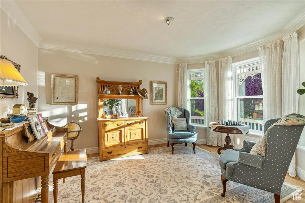 Sitting room featuring baseboards, ornamental molding, and wood finished floors