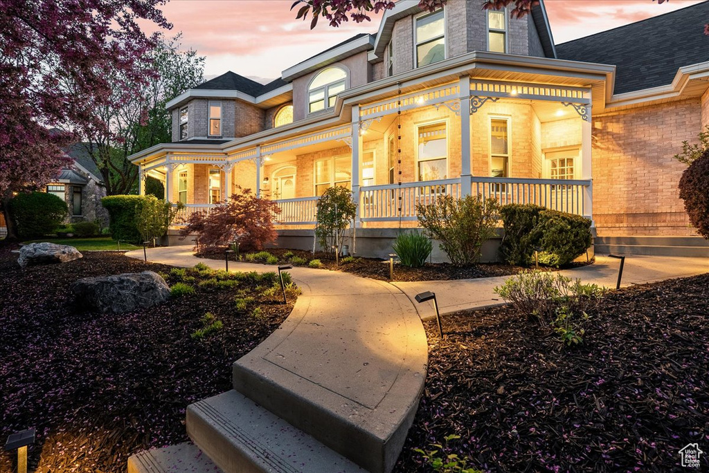 View of front of house featuring a porch and brick siding