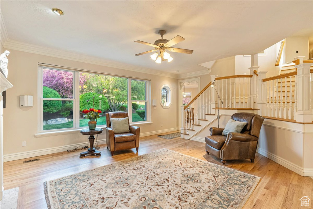 Living area featuring a ceiling fan, stairs, and wood finished floors