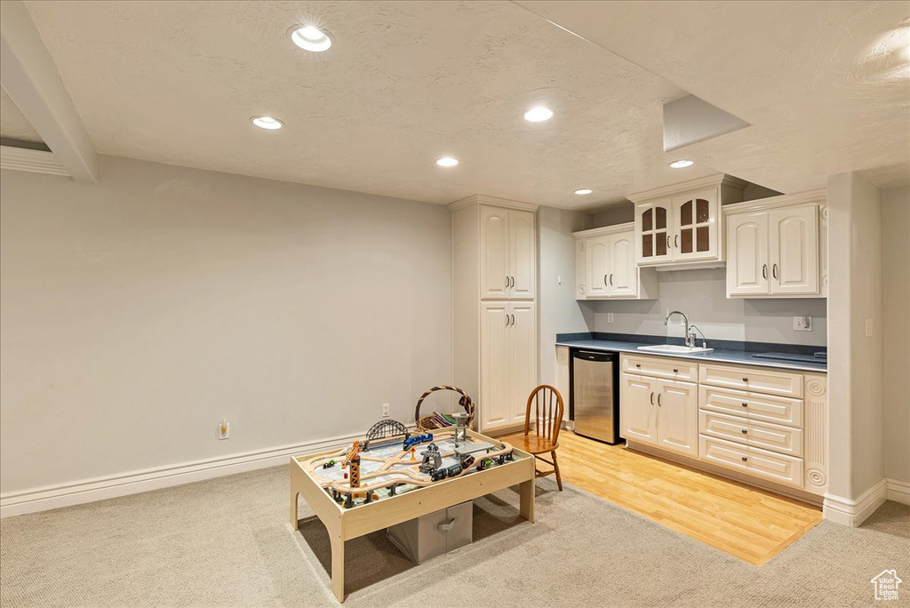 Kitchen featuring stainless steel dishwasher, a sink, recessed lighting, and light carpet