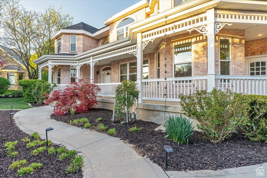View of front facade with a porch and brick siding
