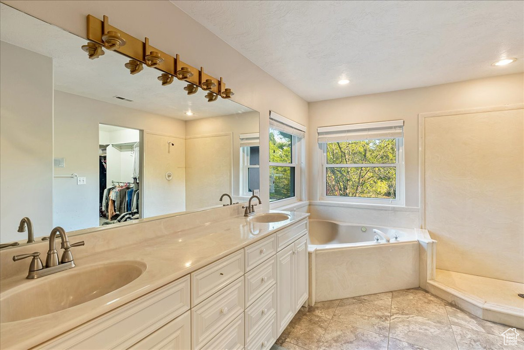 Bathroom with a garden tub, a sink, double vanity, and recessed lighting