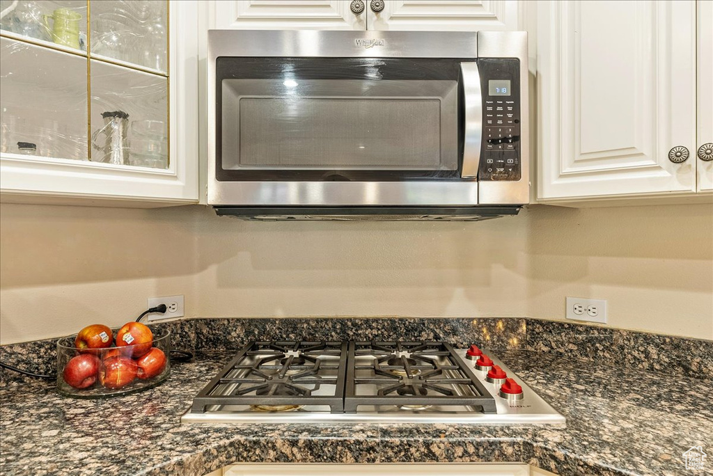 Details with white cabinetry, dark countertops, and stainless steel appliances