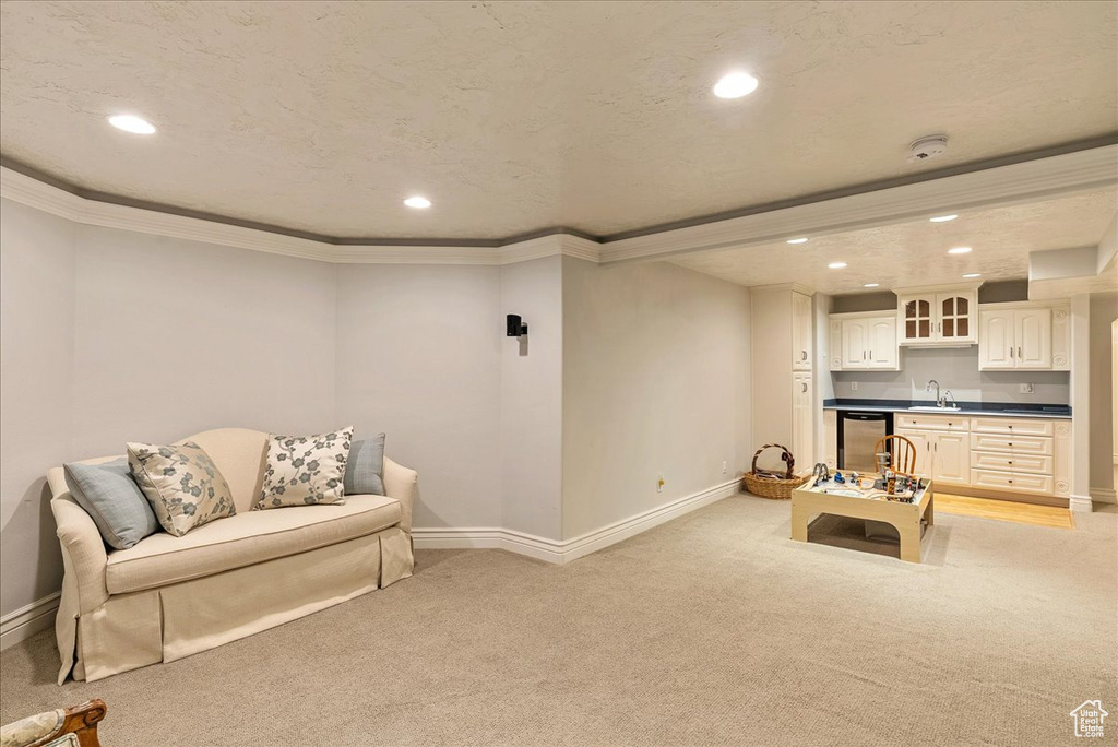 Interior space with indoor wet bar, recessed lighting, baseboards, and light carpet