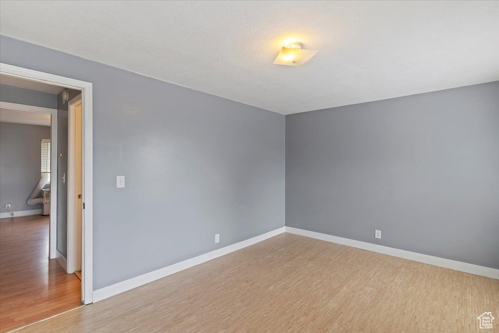 Spare room featuring light wood-style floors and baseboards