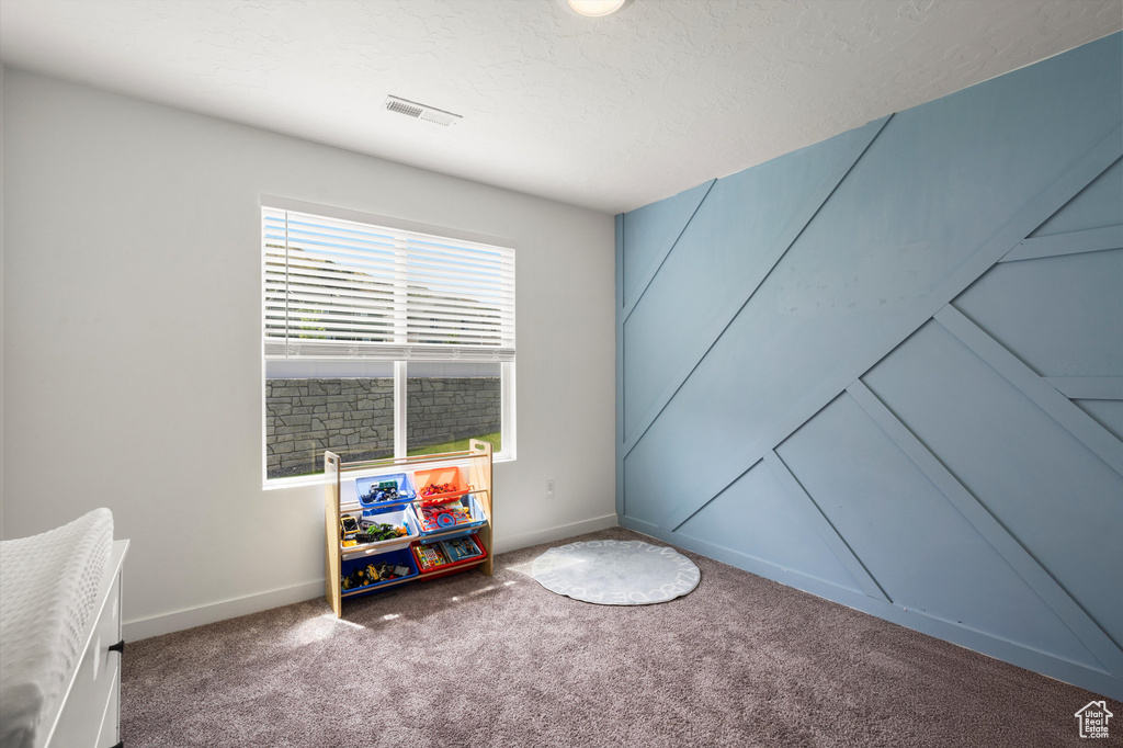 Spare room featuring carpet, baseboards, and a textured ceiling