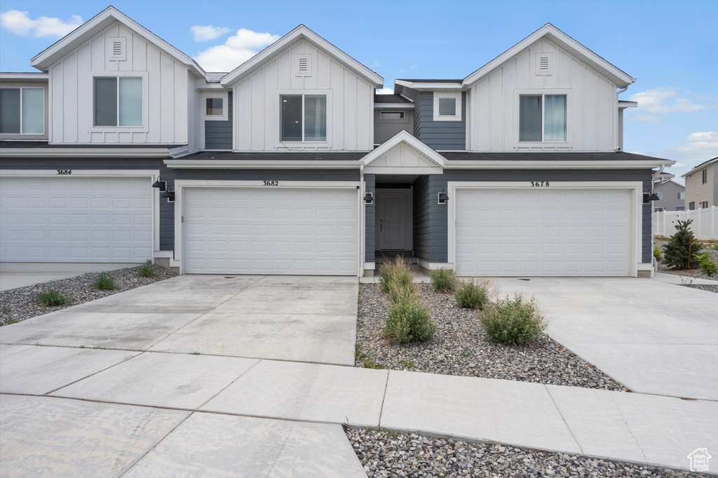 View of front of house with an attached garage, board and batten siding, and concrete driveway