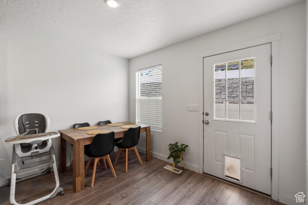 Dining room featuring wood finished floors, baseboards, and a textured ceiling