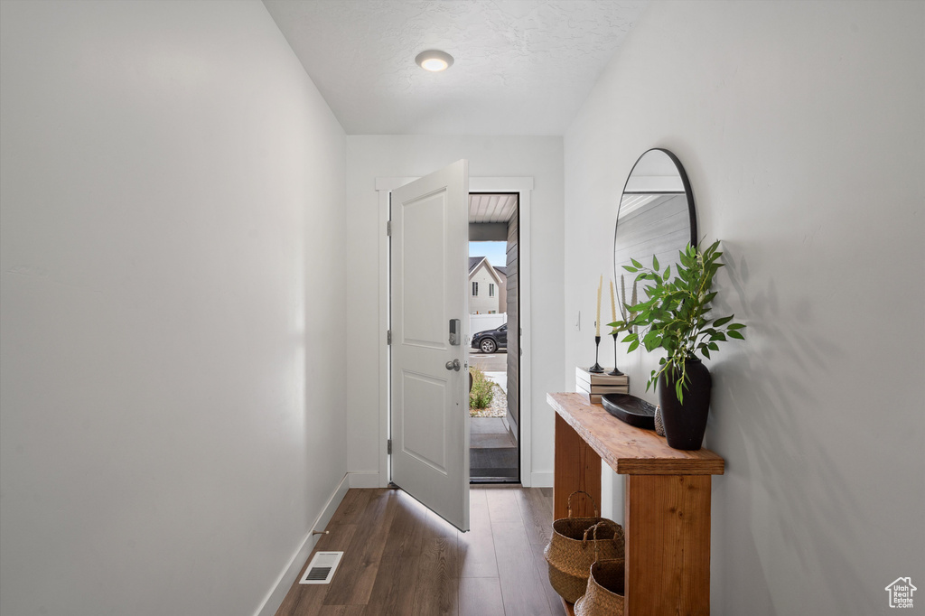 Entrance foyer featuring dark wood-style flooring and baseboards