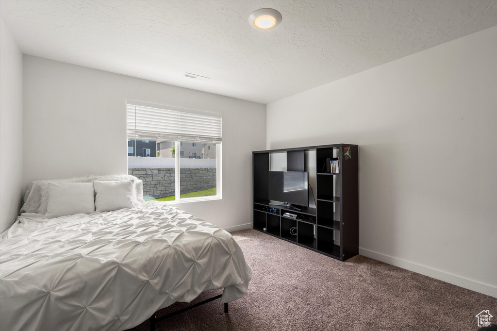 Bedroom featuring light colored carpet and baseboards