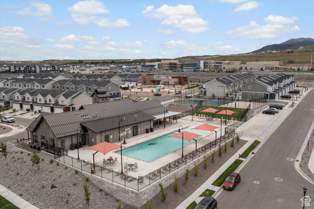 Aerial perspective of suburban area featuring a pool and a mountain backdrop