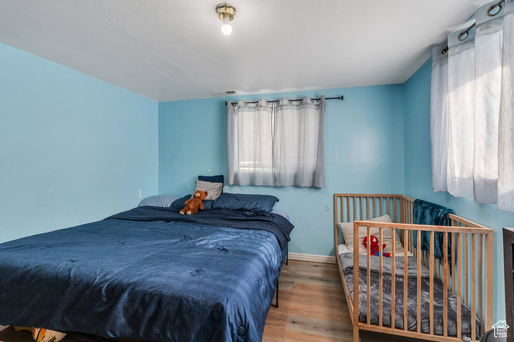 Bedroom featuring multiple windows, wood finished floors, and baseboards