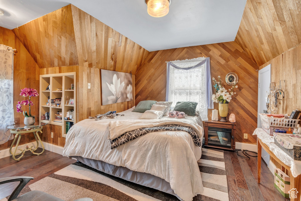 Bedroom with wooden walls, lofted ceiling, wood finished floors, and wooden ceiling