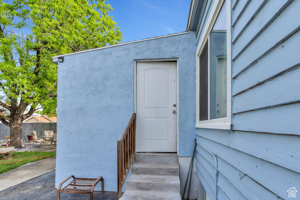 View of exterior entry featuring a patio area and fence