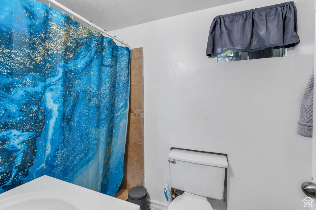 Full bath featuring toilet and a shower with shower curtain