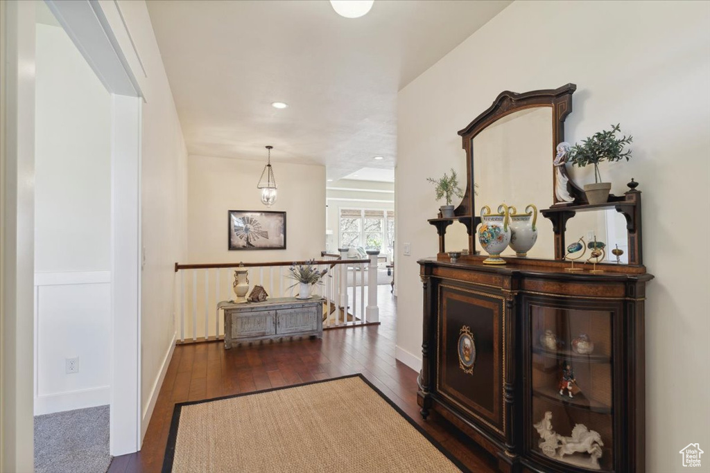 Hallway with dark wood-style flooring, baseboards, and recessed lighting