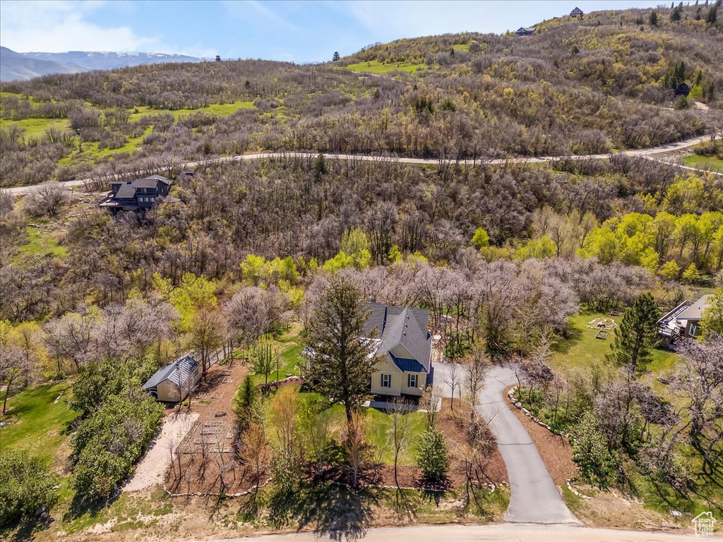 View of subject property featuring a heavily wooded area and mountains