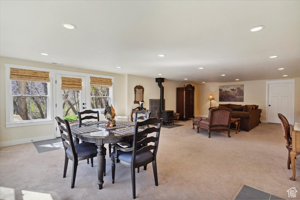 Dining space featuring a wood stove, light colored carpet, recessed lighting, and baseboards