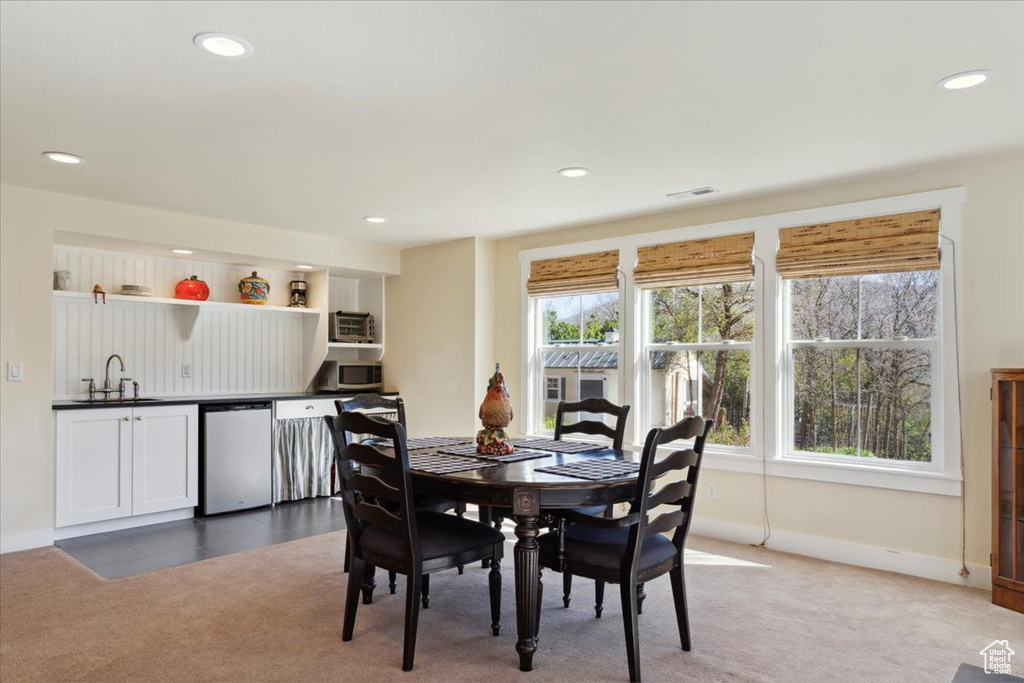Carpeted dining space featuring a sink, recessed lighting, and baseboards