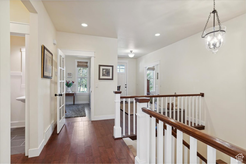 Hallway featuring an upstairs landing, dark wood-type flooring, baseboards, and recessed lighting