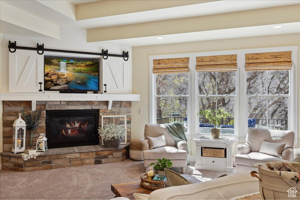 Carpeted living area with a fireplace, a barn door, and recessed lighting