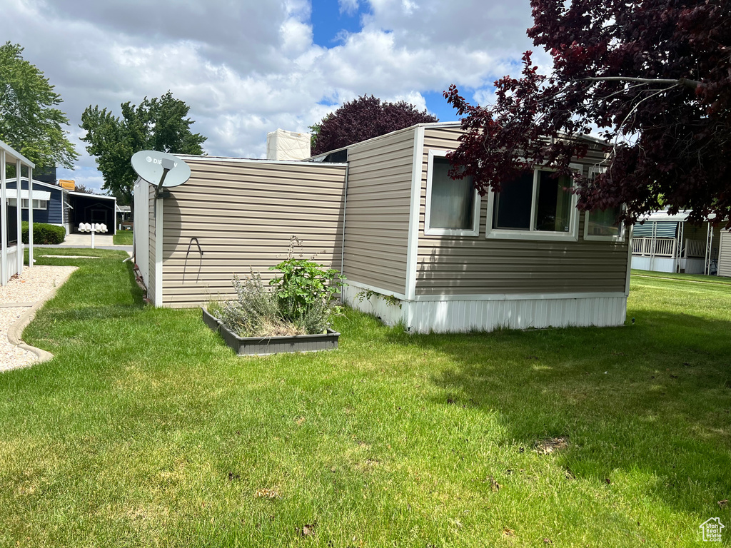 View of home's exterior featuring a lawn and a chimney