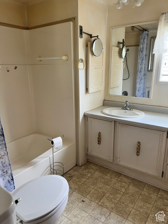 Bathroom with vanity, toilet, and shower / bath combination with curtain