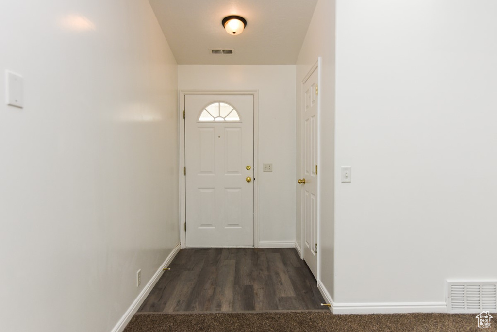 Doorway with baseboards and dark wood finished floors