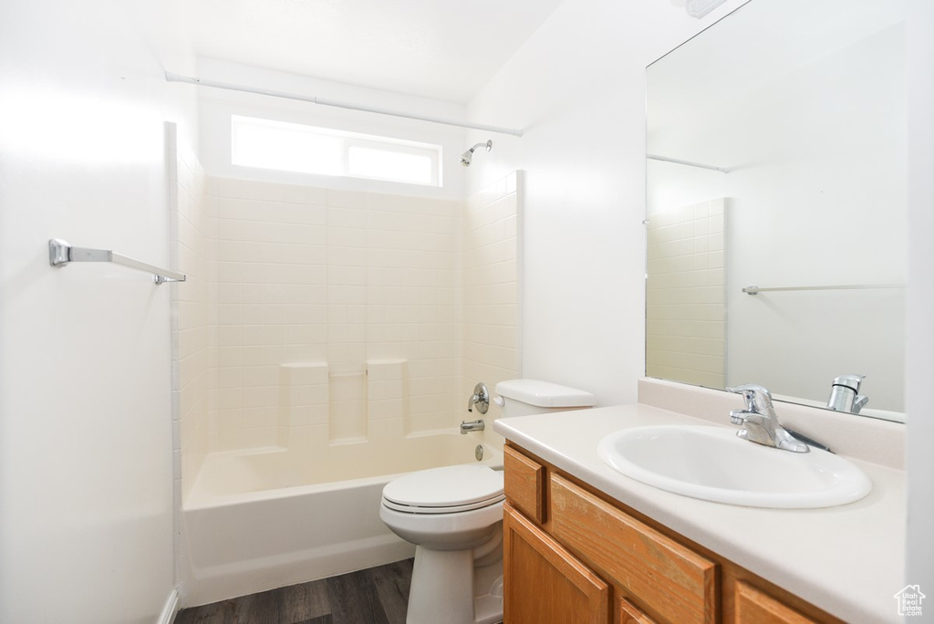 Full bath featuring toilet, vanity, washtub / shower combination, and wood finished floors