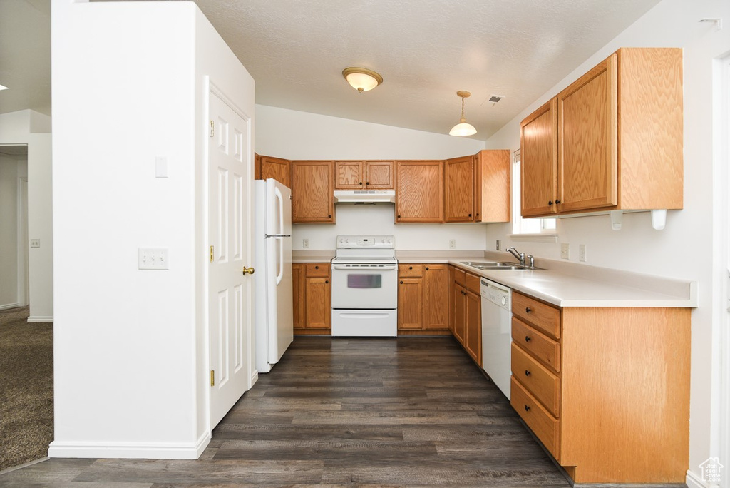 Kitchen featuring white appliances, dark wood finished floors, under cabinet range hood, lofted ceiling, and light countertops