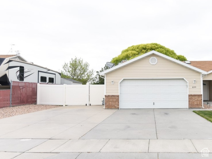 Ranch-style house with driveway, brick siding, and a garage