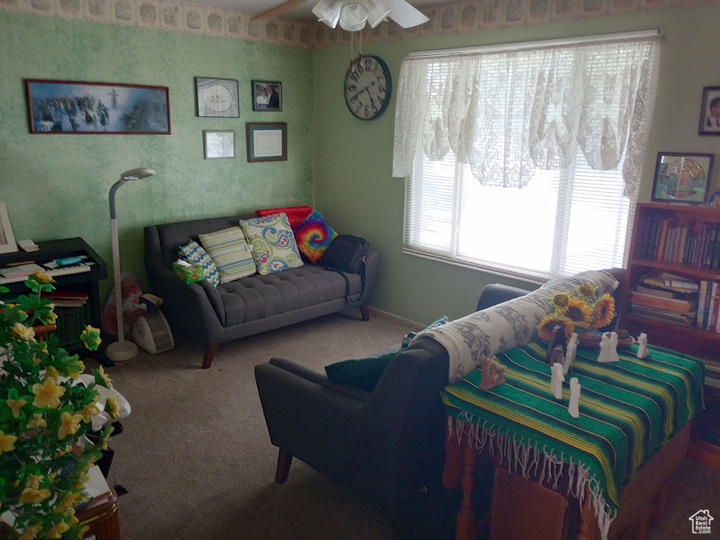 Living area with carpet flooring and a ceiling fan