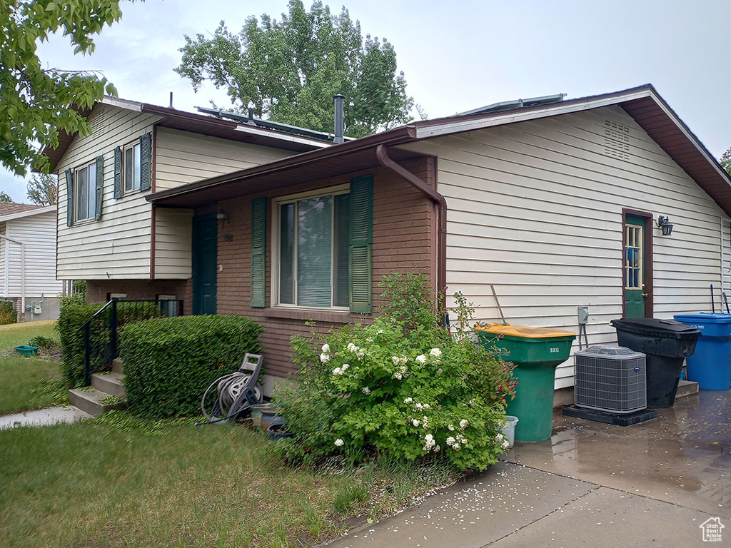 View of home's exterior with brick siding and cooling unit