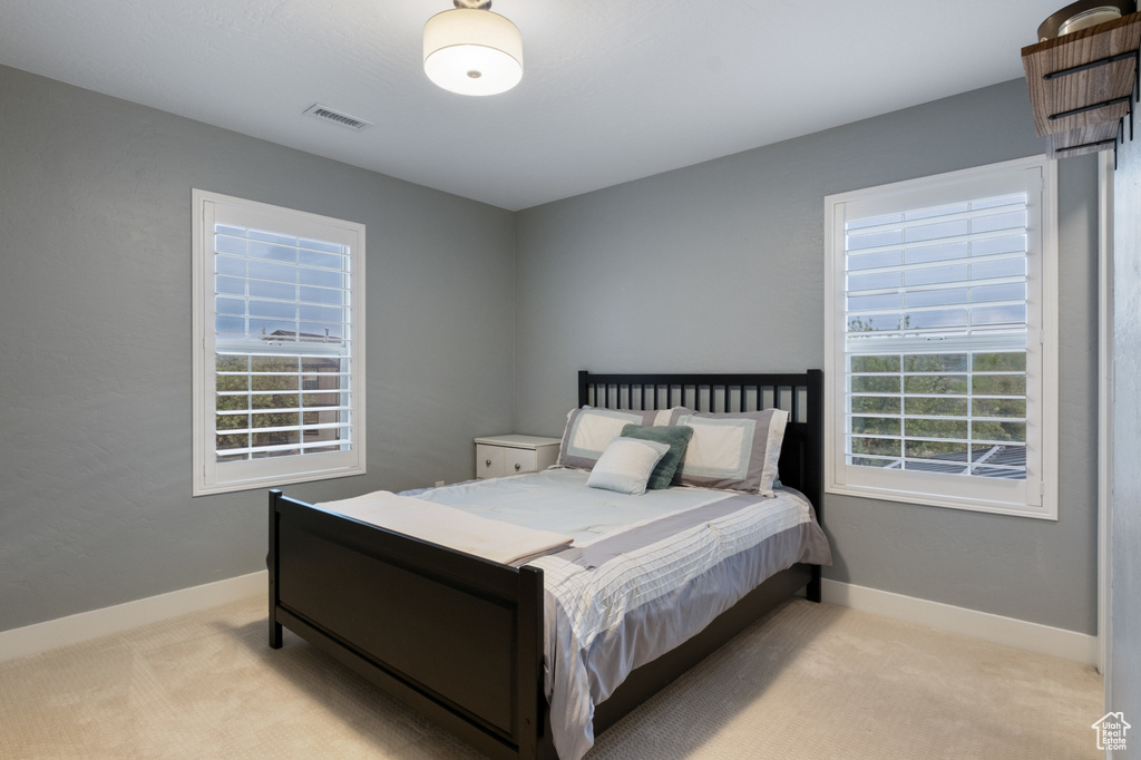 Bedroom featuring light carpet and baseboards