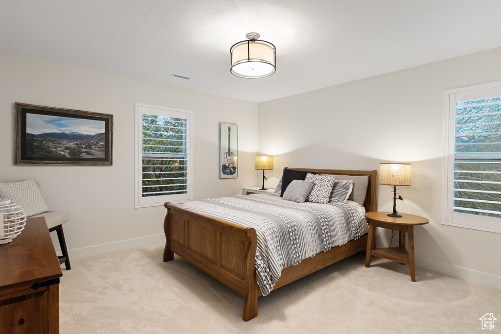 Bedroom featuring light colored carpet and baseboards