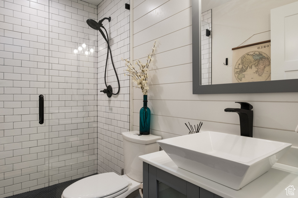 Bathroom featuring a stall shower, toilet, and vanity
